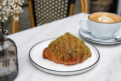 Delicious croissant and coffee on white marble table