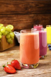 Photo of Glasses with tasty smoothies and ingredients on wooden table