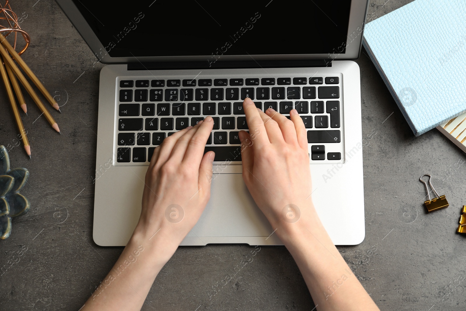 Photo of Woman using modern laptop at table, top view