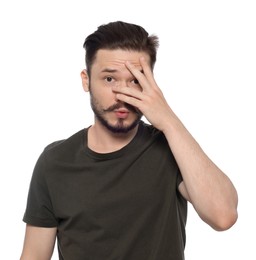 Embarrassed man covering face with hand on white background