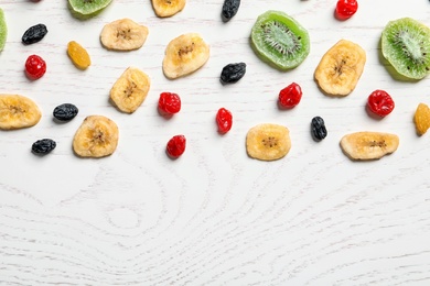 Photo of Flat lay composition with different dried fruits on wooden background, space for text. Healthy lifestyle