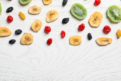 Flat lay composition with different dried fruits on wooden background, space for text. Healthy lifestyle