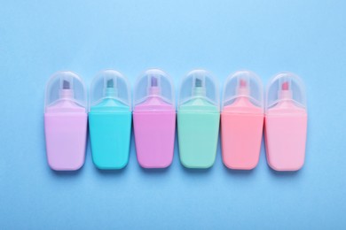 Photo of Many colorful markers on light blue background, flat lay