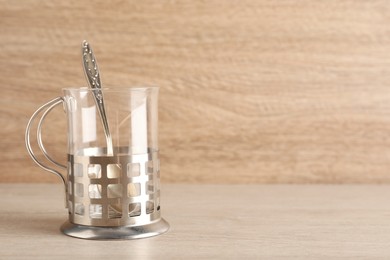 Photo of Traditional tea glass holder on wooden table, space for text