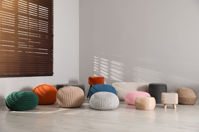 Many stylish different poufs in room. Home design