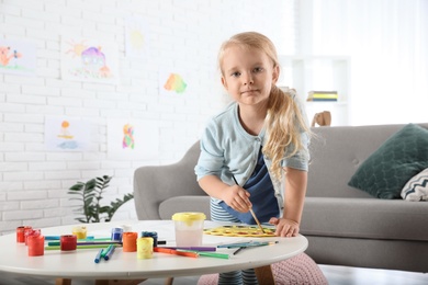 Photo of Cute little child painting at table indoors