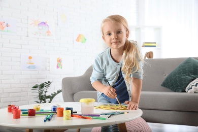 Cute little child painting at table indoors