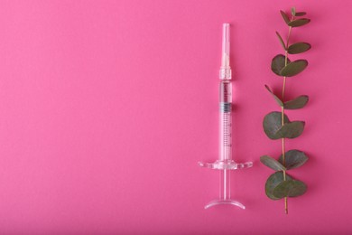 Photo of Cosmetology. Medical syringe and eucalyptus branch on pink background, flat lay. Space for text