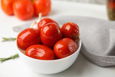 Pickled tomatoes in bowl on white table