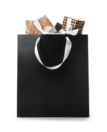 Photo of Paper shopping bag with handles full of gift boxes on white background. Mock up for design