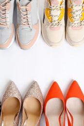 Frame of different shoes on white background, top view with space for text