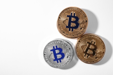 Golden and silver bitcoins on white background, top view. Digital currency
