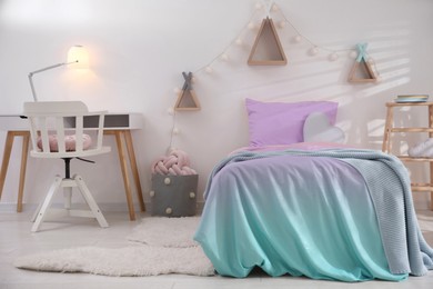 Photo of Comfortable bed with pink linens in children's room