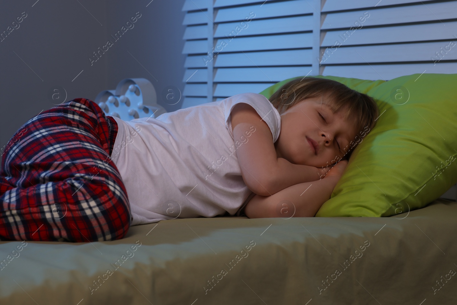 Photo of Little boy snoring while sleeping on bed at night