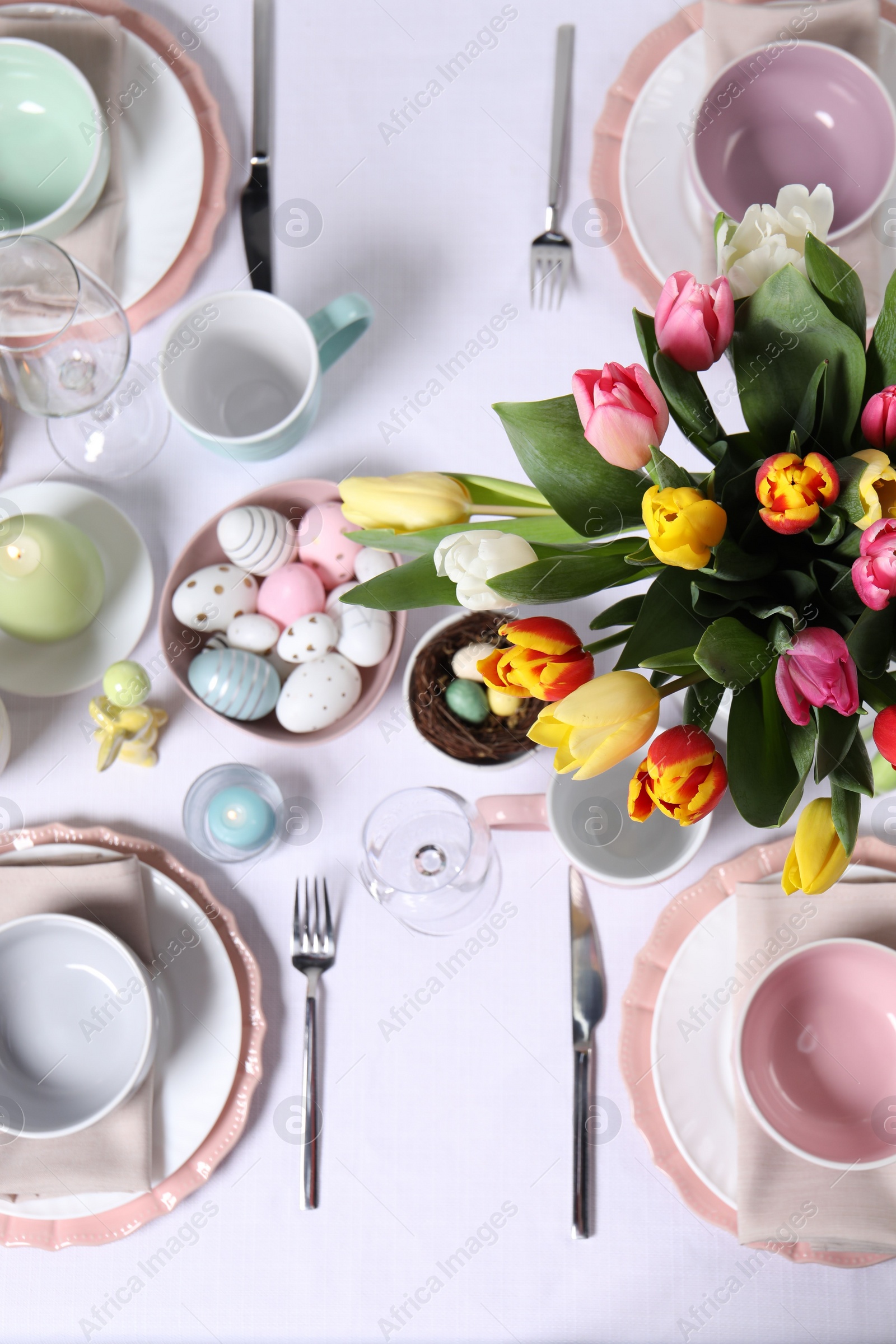 Photo of Festive table setting with beautiful flowers, flat lay. Easter celebration