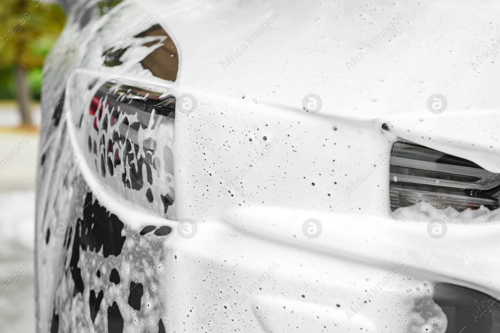 Photo of Auto with cleaning foam at car wash, closeup