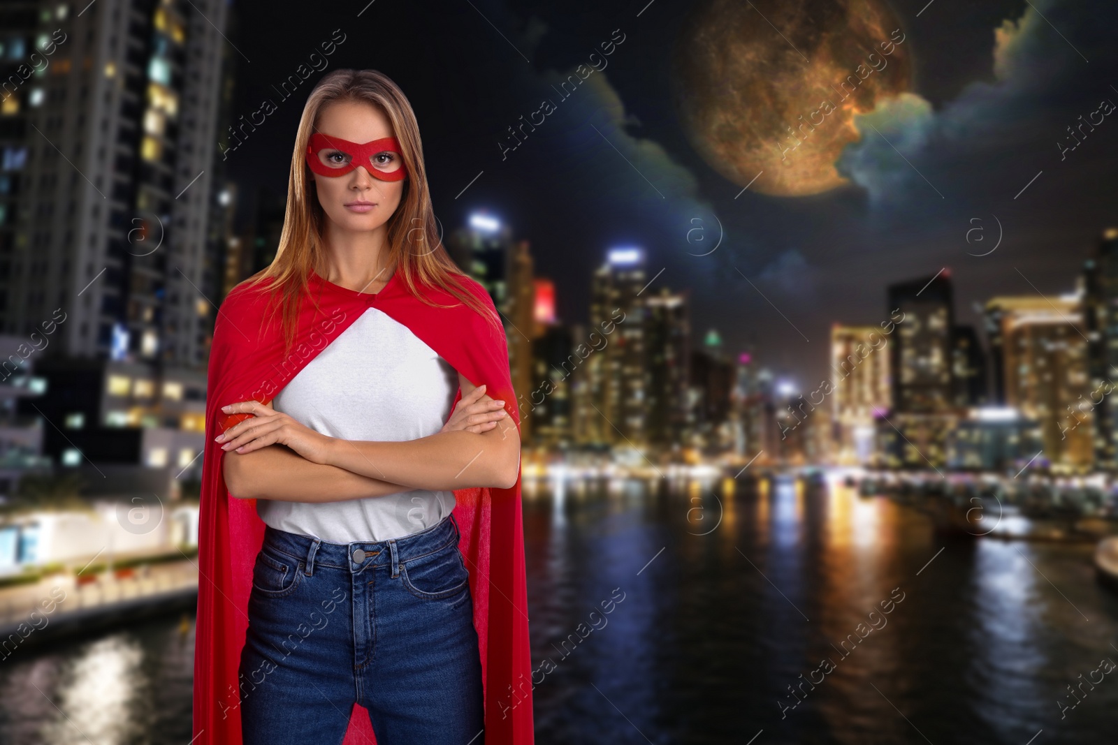 Image of Confident woman wearing superhero costume and beautiful cityscape in night on background