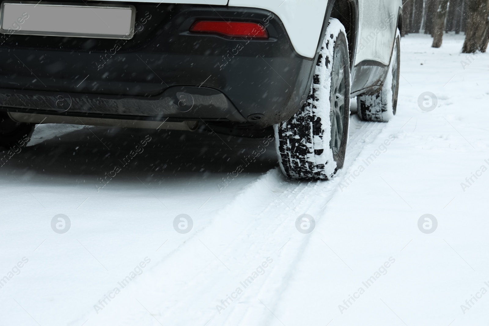 Photo of Car leaving tire tracks on snowy road outdoors