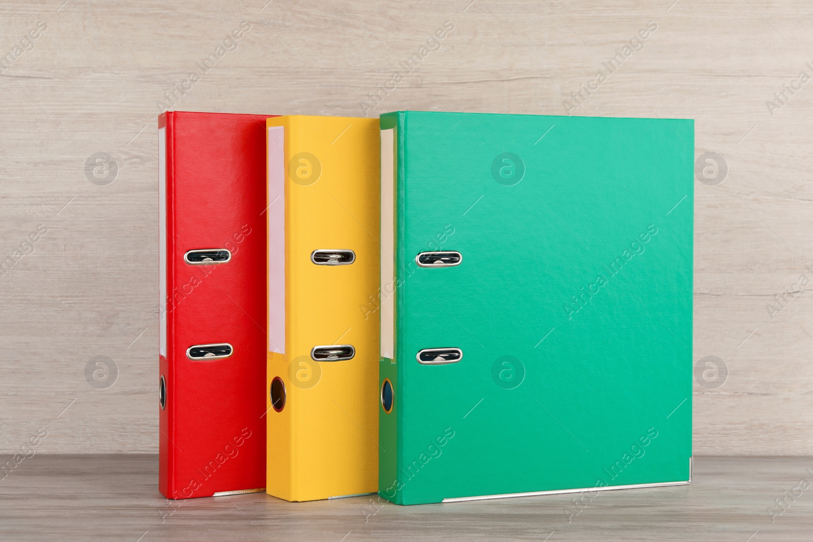 Photo of Bright hardcover office folders on white wooden table
