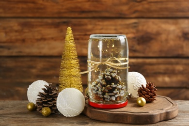 Handmade snow globe and Christmas decorations on wooden table