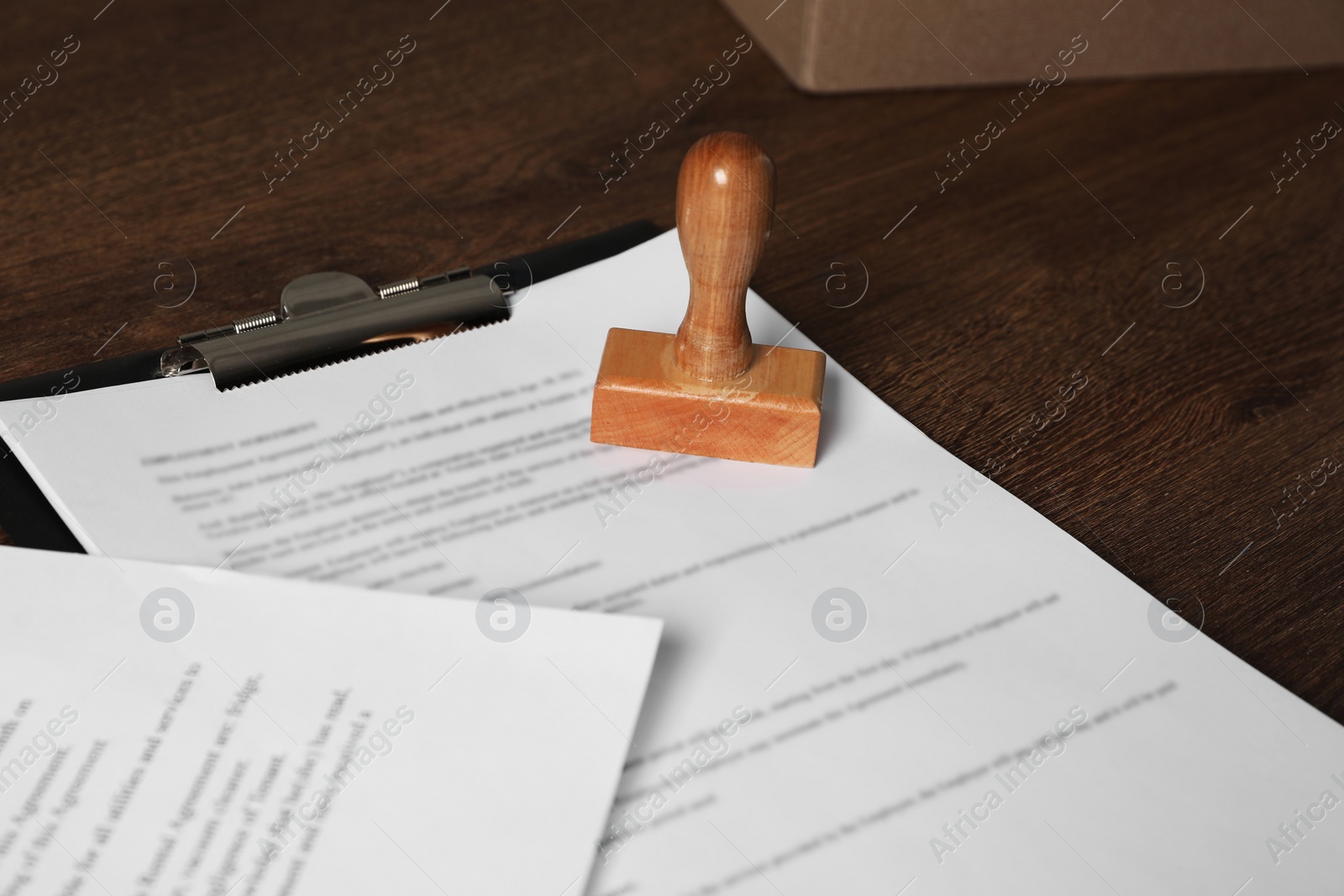 Photo of Documents and stamp on wooden table. Notary contract