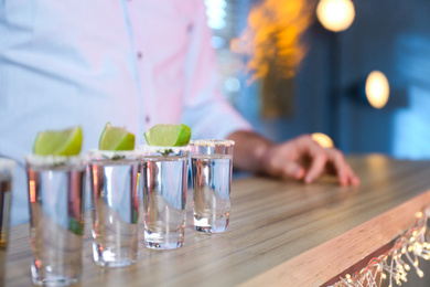 Mexican Tequila shots with salt and lime slices on bar counter