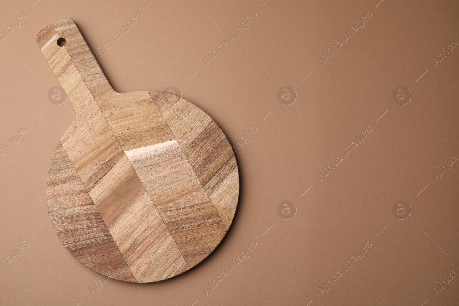 Photo of One wooden board on beige background, top view. Space for text