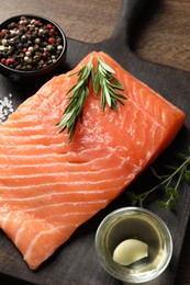 Photo of Fresh raw salmon and ingredients for marinade on wooden table