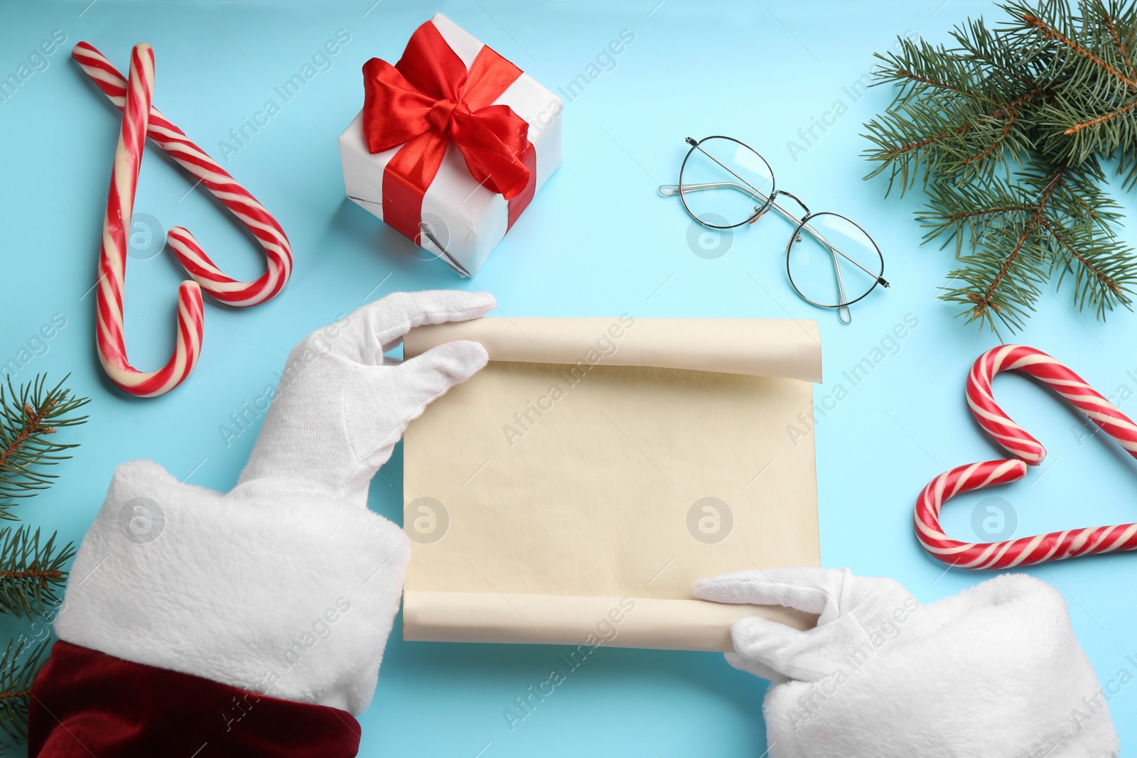 Photo of Santa with letter at light blue table, top view