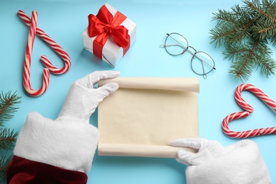 Photo of Santa with letter at light blue table, top view