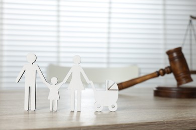 Photo of Family law. Figure of parents with children and gavel on light wooden table, space for text