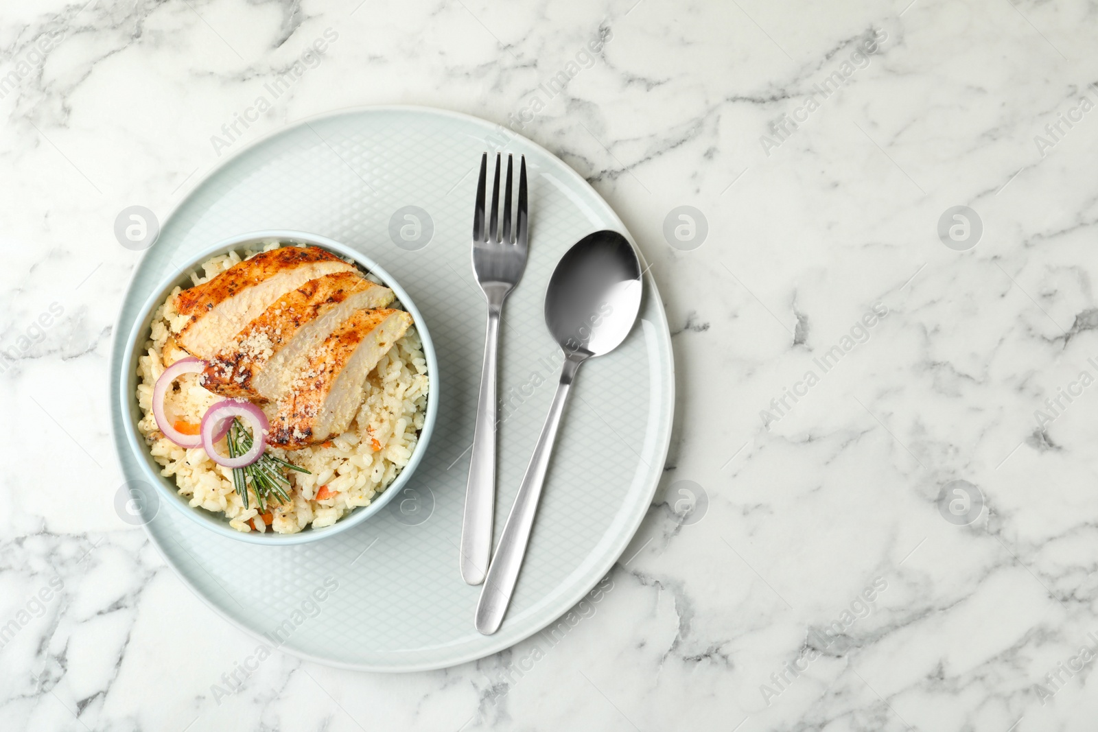 Photo of Delicious chicken risotto served on white marble table, top view. Space for text