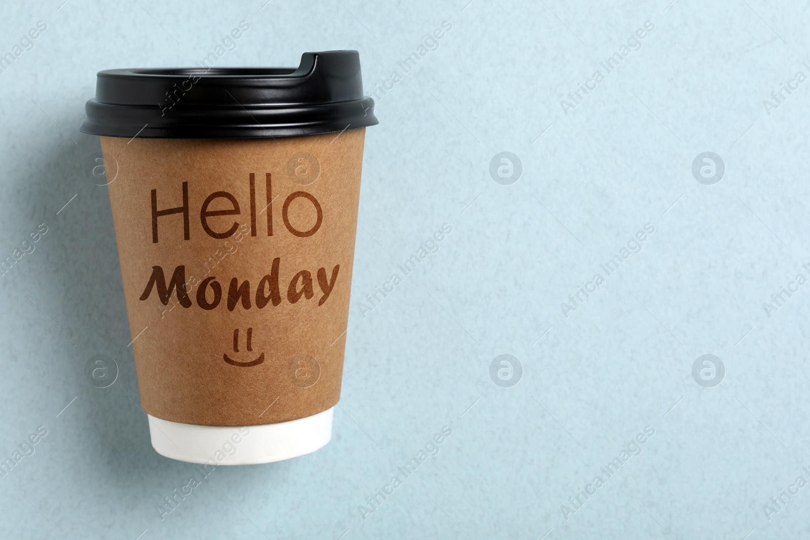 Image of Start your week with good mood. Paper cup with phrase Hello Monday on light blue background, top view