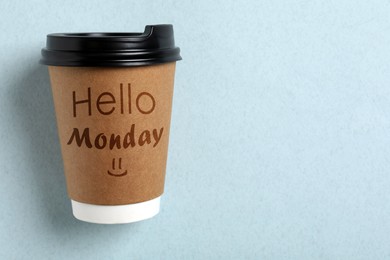 Image of Start your week with good mood. Paper cup with phrase Hello Monday on light blue background, top view