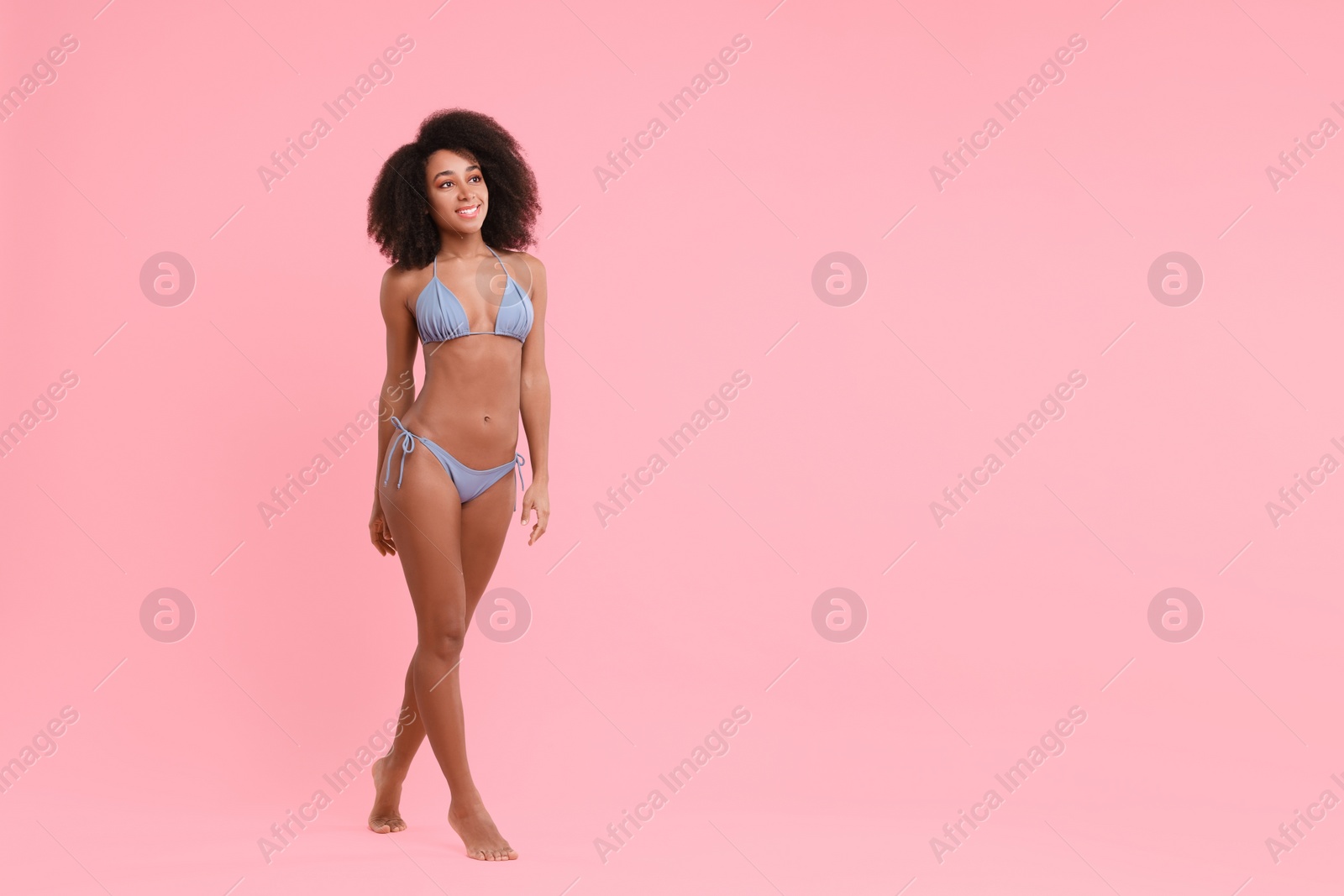 Photo of Beautiful woman in stylish bikini on pink background, space for text