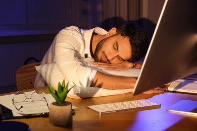 Photo of Tired man fell asleep at workplace in office