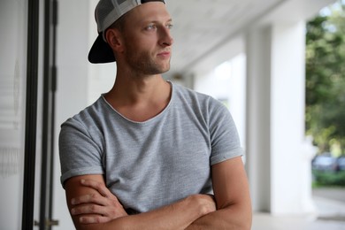 Photo of Handsome young man in stylish cap indoors