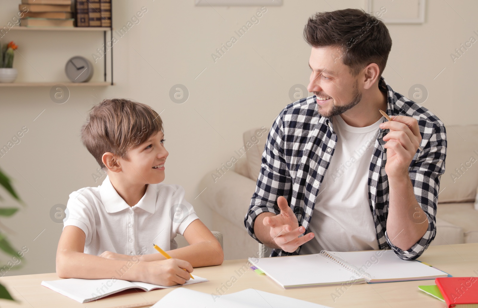 Photo of Dad helping his son with school assignment at home