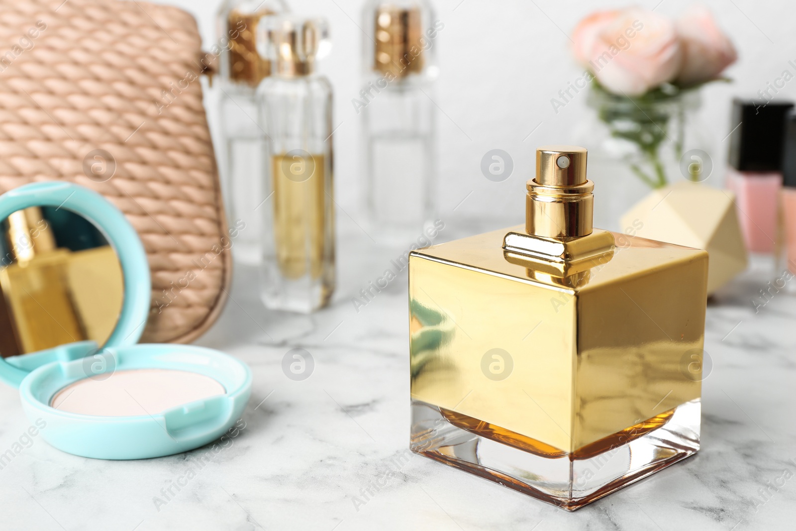 Photo of Bottle of perfume and cosmetics on marble table. Space for text