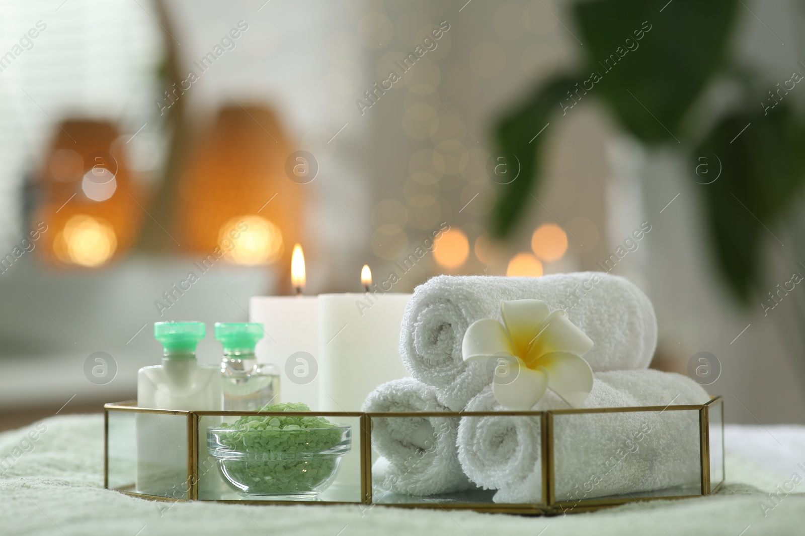 Photo of Composition with different spa products and burning candles on table indoors