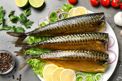 Flat lay composition with tasty smoked fish on grey table