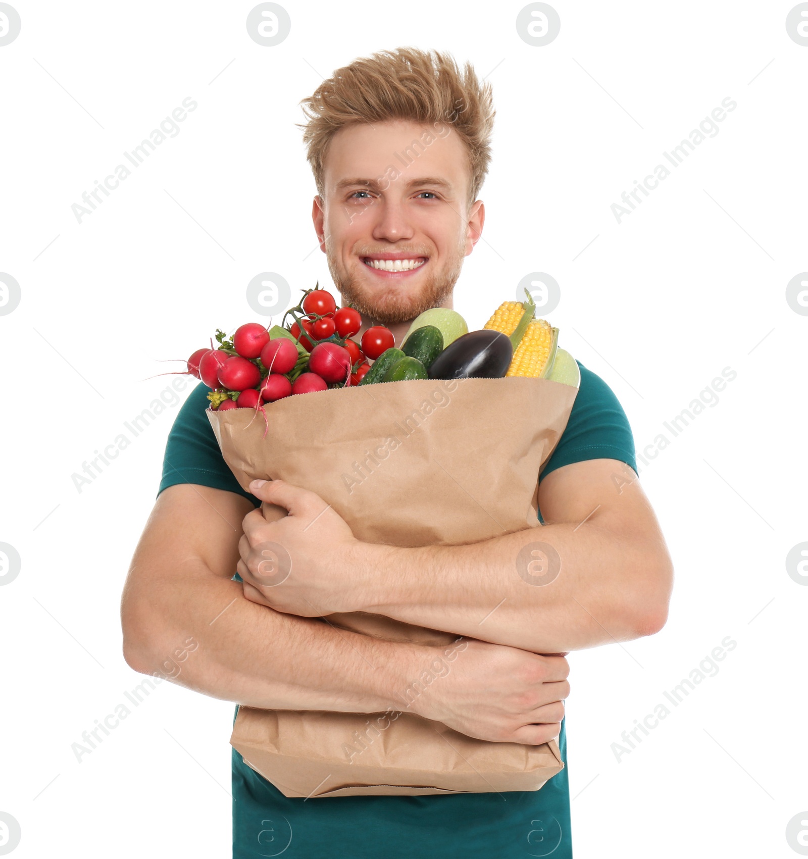 Photo of Young man with bag of fresh vegetables on white background