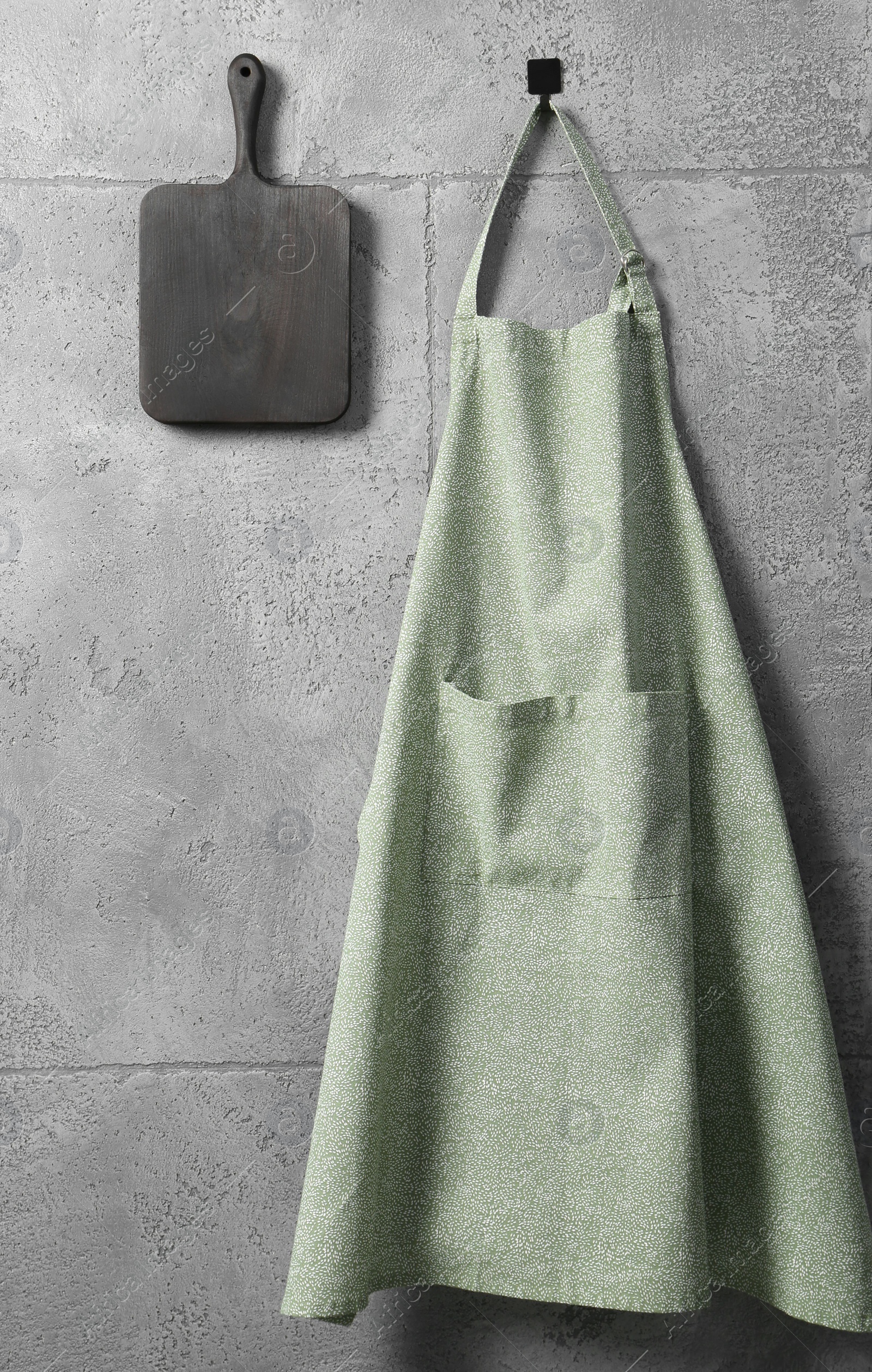 Photo of Clean kitchen apron with pattern and board on grey tiled wall