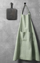 Photo of Clean kitchen apron with pattern and board on grey tiled wall