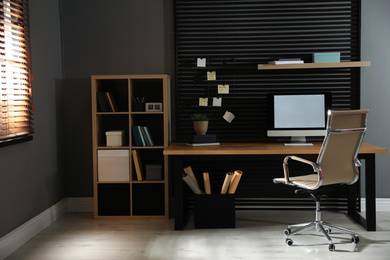 Photo of Comfortable workplace with computer and office chair. Stylish room interior