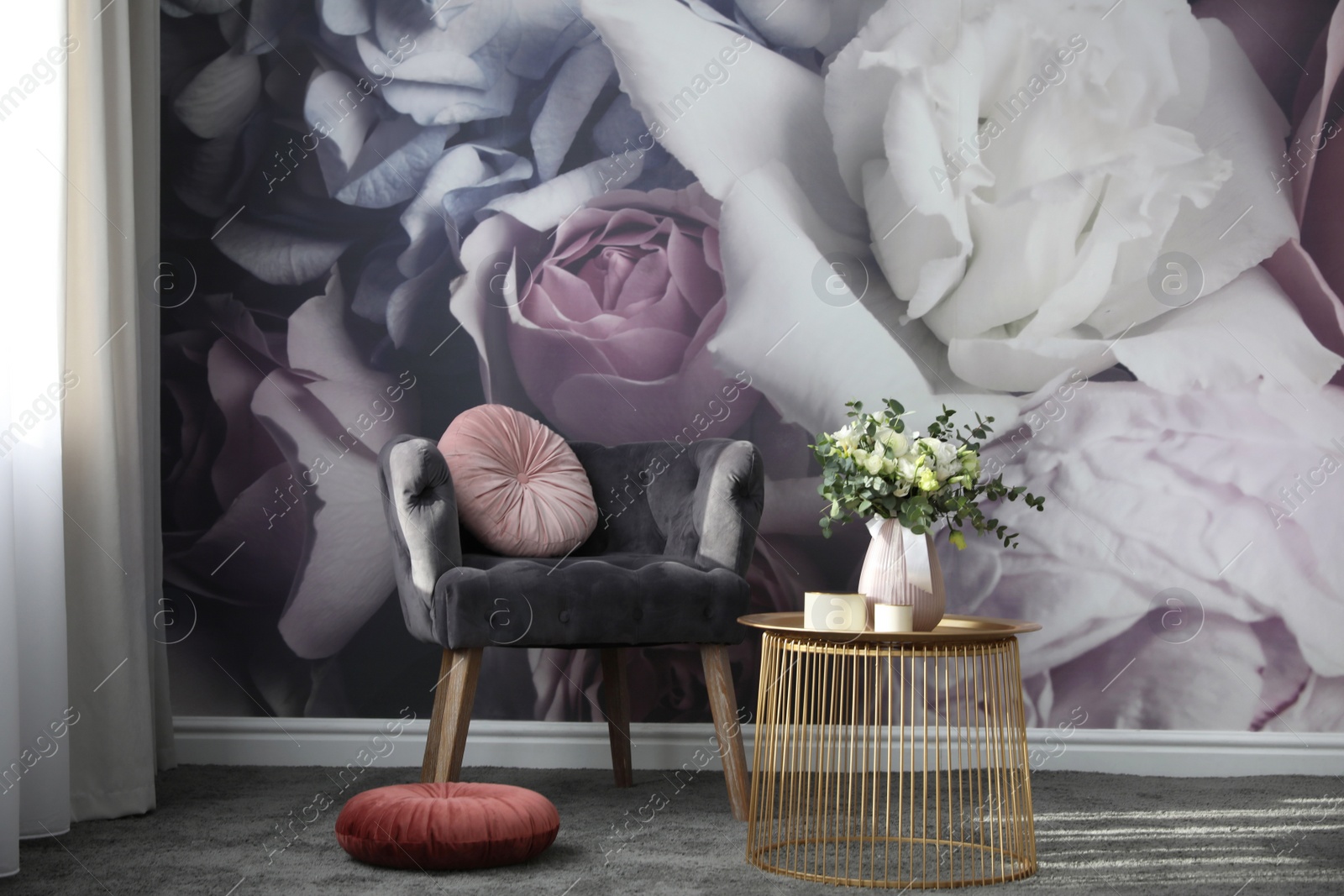 Photo of Comfortable armchair near wall with floral print. Stylish room interior