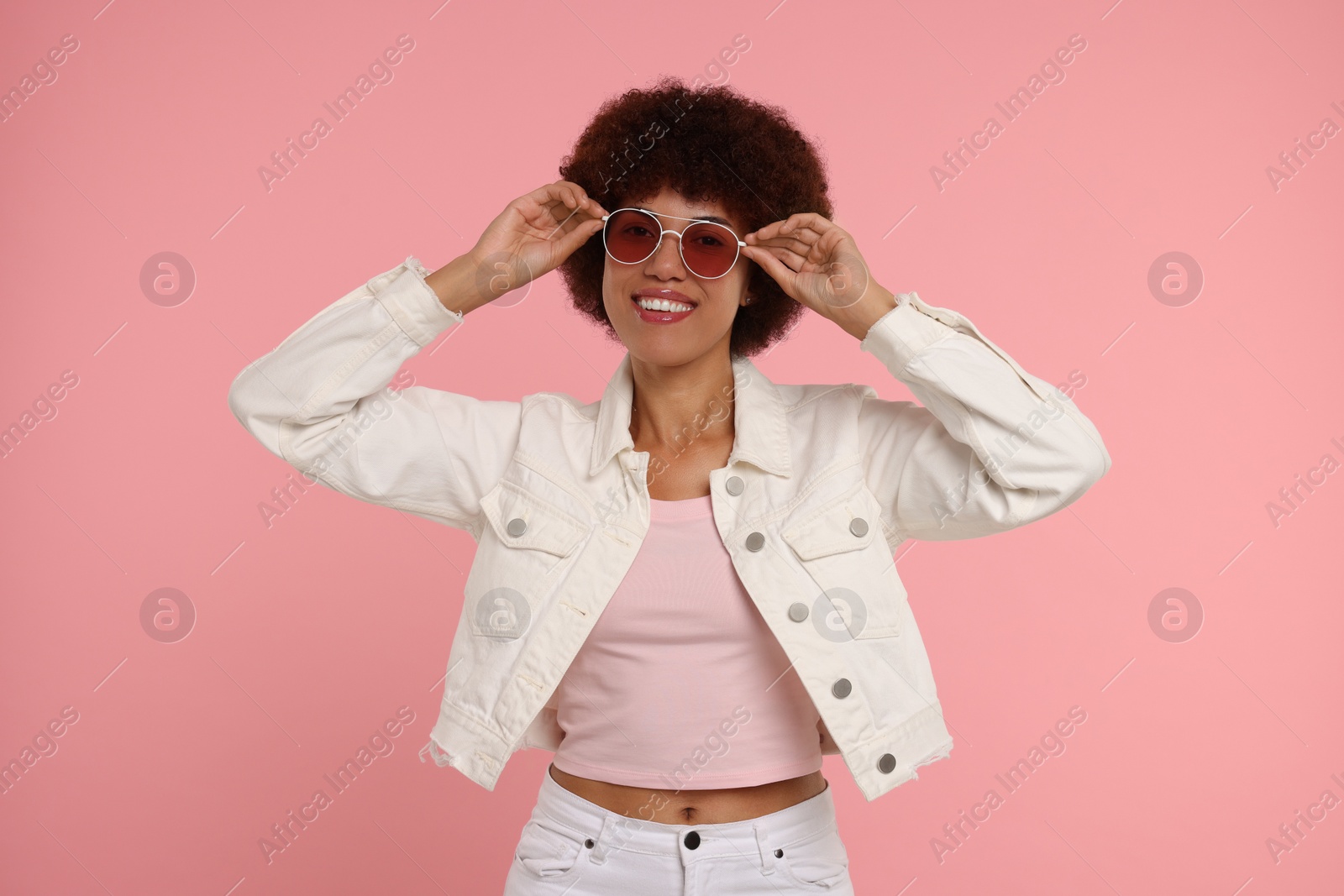 Photo of Portrait of young woman in sunglasses on pink background