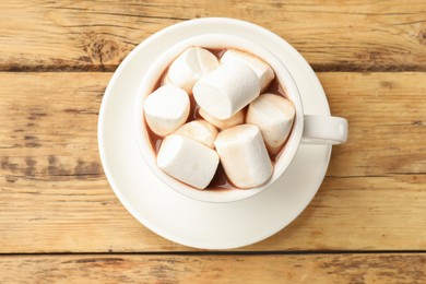 Photo of Tasty hot chocolate with marshmallows on wooden table, top view
