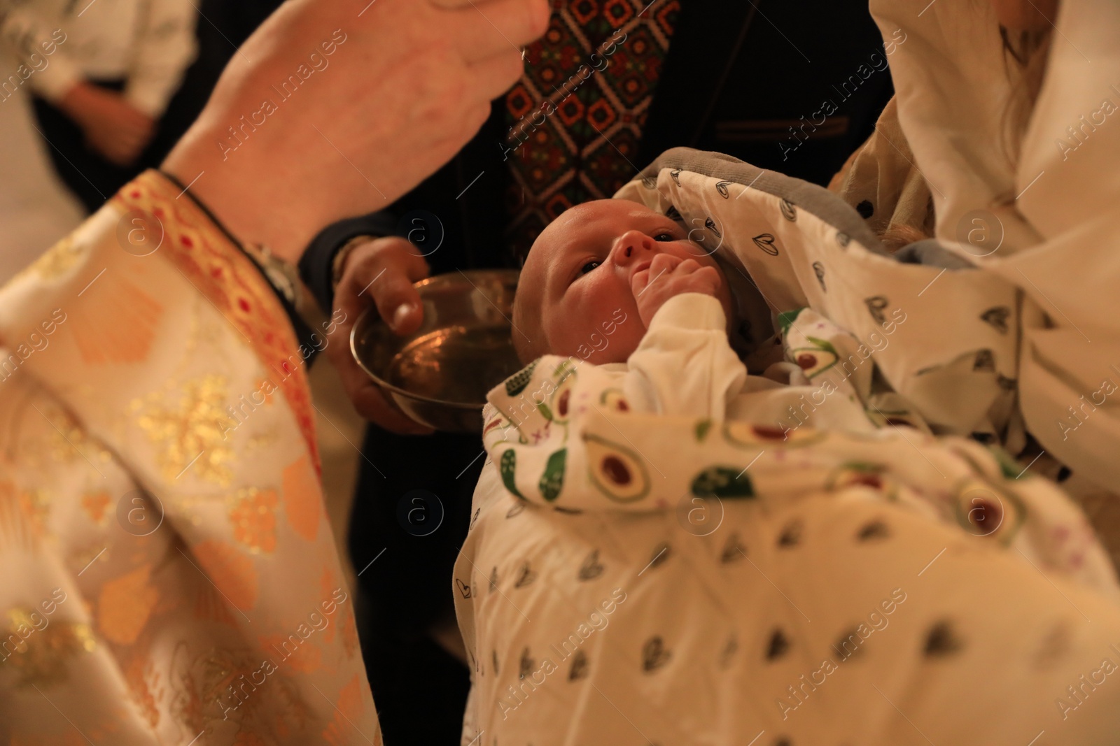 Photo of Stryi, Ukraine - September 11, 2022: Priest conducting baptism ceremony in Assumption of Blessed Virgin Mary cathedral