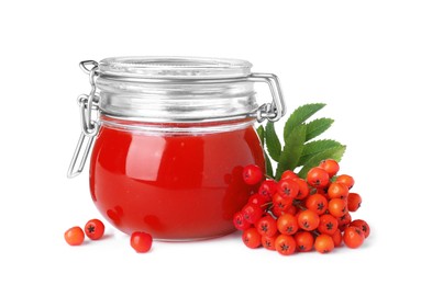 Photo of Delicious rowan jam in glass jar and berries with green leaves on white background